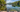 Clear shallow freshwater with stones and aquatic plants beside a dock and small kayak