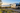 Silver travel trailer beside coastal grasses at an ocean campground