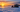 Ice fishing shelter and bundled angler on a frozen lake at sunrise