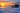 Ice fishing shelter and bundled angler on a frozen lake at sunrise