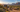 Camper van at a sunlit off-grid campsite in a desert valley