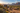 Camper van at a sunlit off-grid campsite in a desert valley